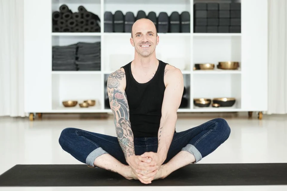 Will smiling, seated comfortably on a yoga mat
